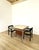 A unique double-desk centerpiece, featuring a metal frame and wooden elements, and a top covered in ivory-colored faux...