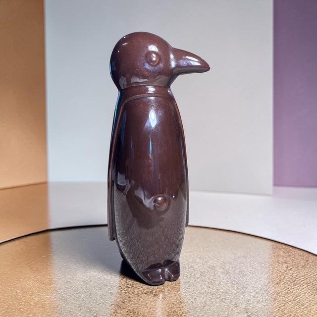 Add a touch of whimsical modern design to your space with this striking glazed ceramic penguin sculpture. Standing 13...