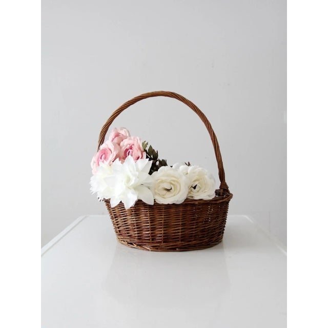 This is a vintage handle basket. The woven wicker basket features a twisted handle and top frame. Classic harvest basket,...