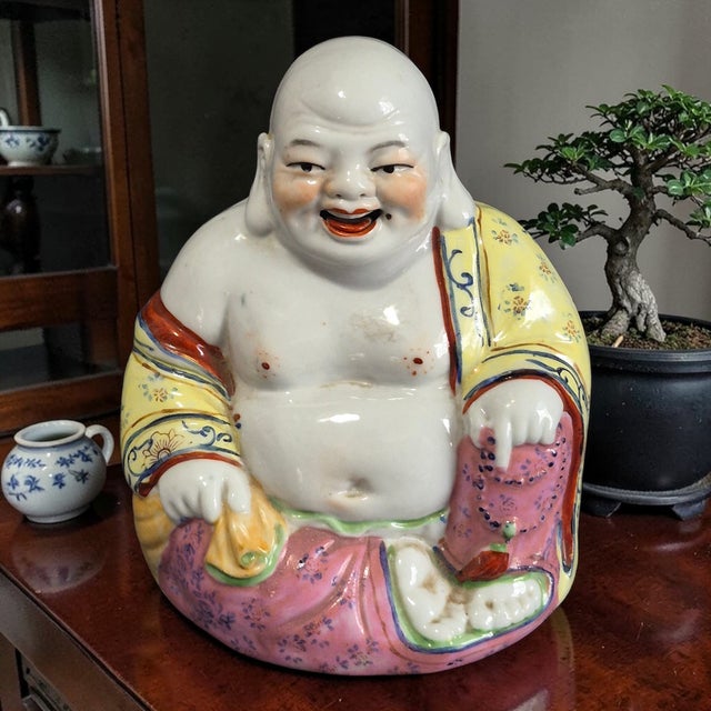 This vintage Famille Rose hand-painted laughing Buddha figurine is a unique and charming piece that showcases intricate...