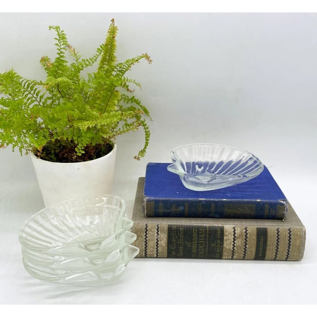 Stunning transparent glass serving bowls shaped like clam shells. Lovely detail and texture make this an eye-catching,...
