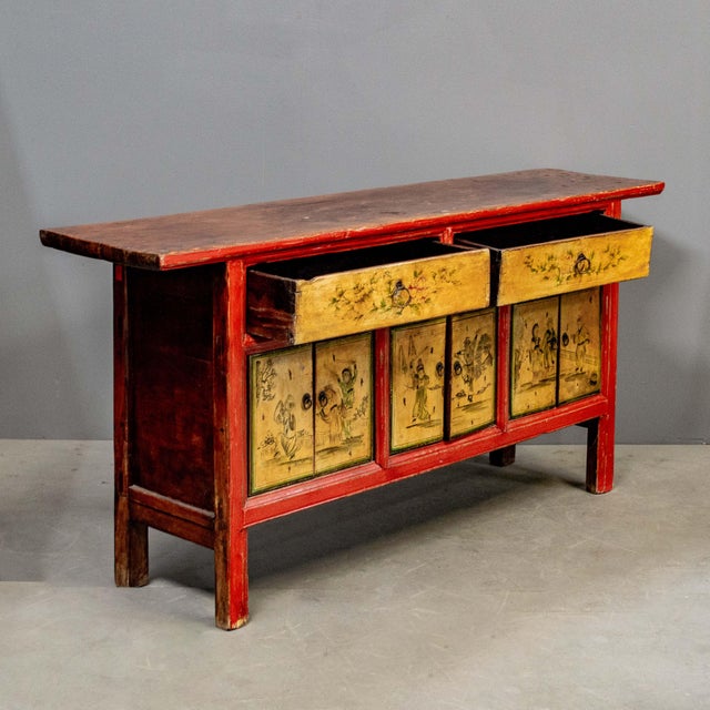 Authentic early 1900's Chinese sideboard featuring vibrant red framing with hand-painted yellow panels depicting...