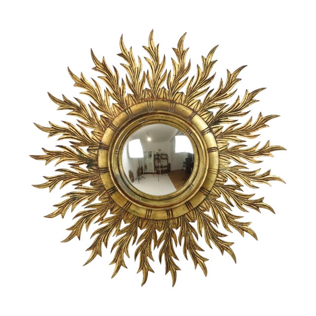 Beautiful and extremely rare gold-colored sunburst mirror, with convex glass, made entirely of wood gilded with gold leaf,...