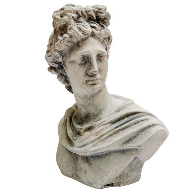 Cast concrete bust depicting Apollo with classical draped garments and a laurel crown. Honoring the celebrated marble...