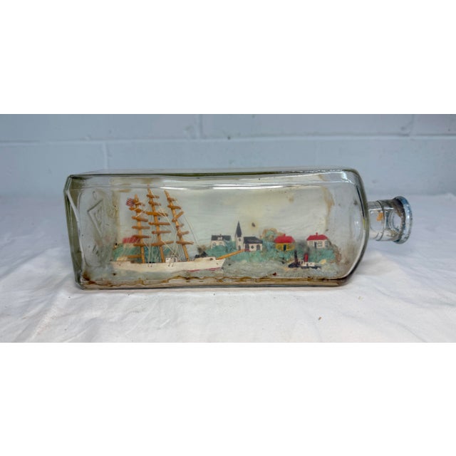 original creation features a nautical theme and depicts a detailed sailing ship cruising the coast. There is several homes...