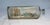 original creation features a nautical theme and depicts a detailed sailing ship cruising the coast. There is several homes...