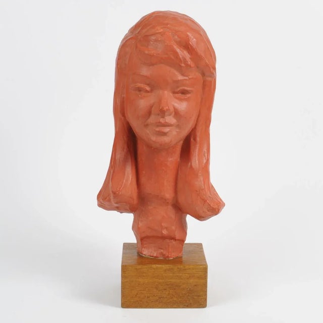 This terracotta bust on a hardwood base is signed at the back. This piece has an attribution mark, I am sure that it is...