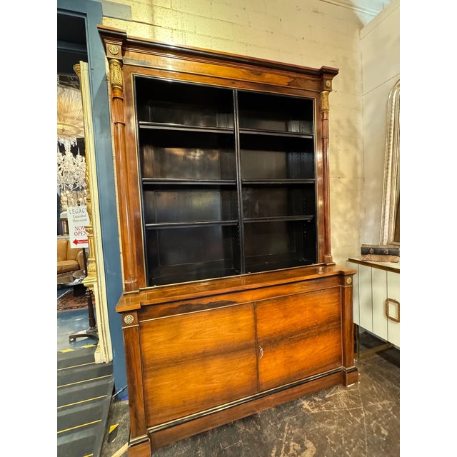 The Pair of French Empire Walnut Display Cabinets is a set of antique furniture pieces that exude elegance and...