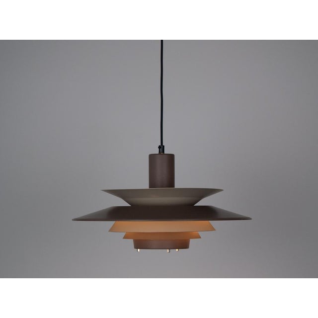 The lamp's form was designed based on the principle of a reflective system that directs light not only downward but also...