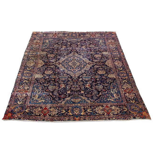 This vintage Kashan hand-knotted wool rug has a navy blue field and multicolor accents throughout the design. This rug...