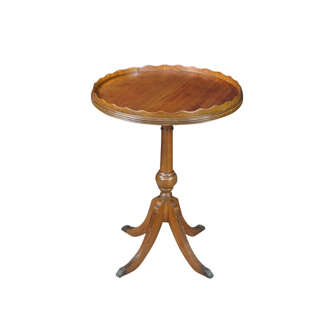 This elegant circa 1940s Georgian-style pedestal accent table is crafted from rich, warm-toned mahogany and features a...