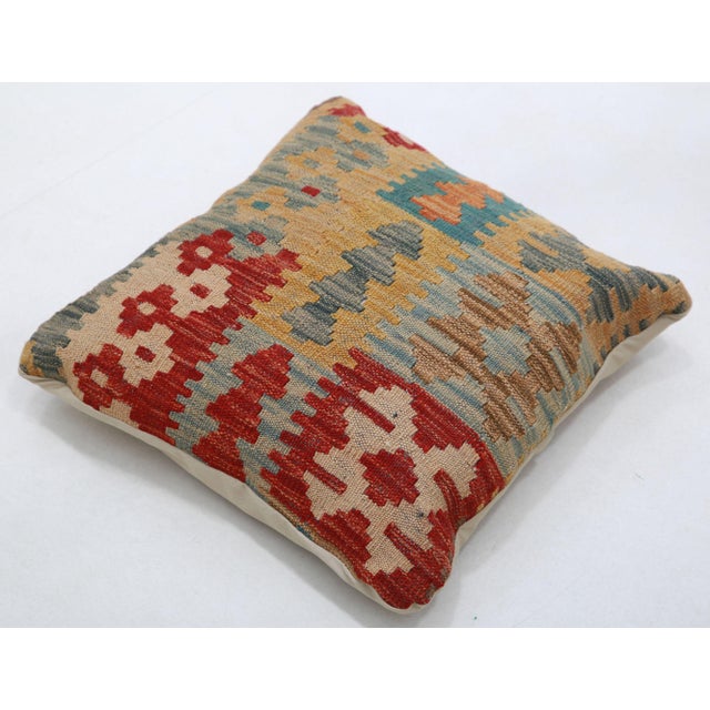 A one-of-a-kind handwoven Afghan wool kilim accent pillow featuring patchwork of geometric motif blocks. Cut and sewn by...