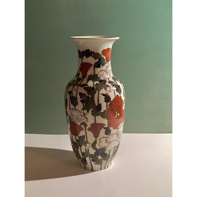 A beautiful ceramic vase patterned with flowing scarlet & white flowers on tall green stems in a classical urn shape...