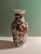 A beautiful ceramic vase patterned with flowing scarlet & white flowers on tall green stems in a classical urn shape...