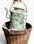 An antique Chinese famille rose porcelain teapot, circa 1890 - 1900, with its fitted woven warming basket and padded...
