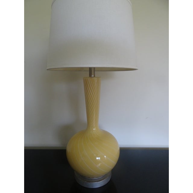 A beautiful vintage yellow glass with swirling lines and a silver leaf base and neck. Shade included. Shade width 15"...