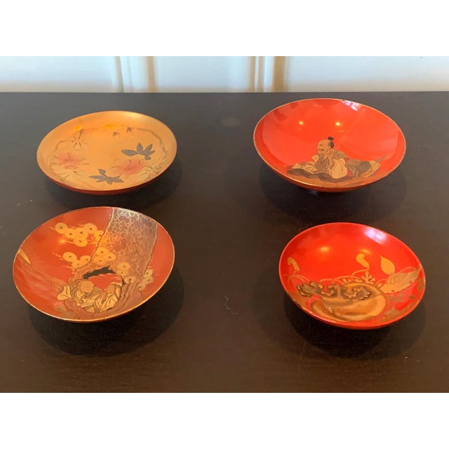 An assemble of four lacquerware sake cups from Meiji period Japan circa late 19th century. The shadow cups on an elevated...