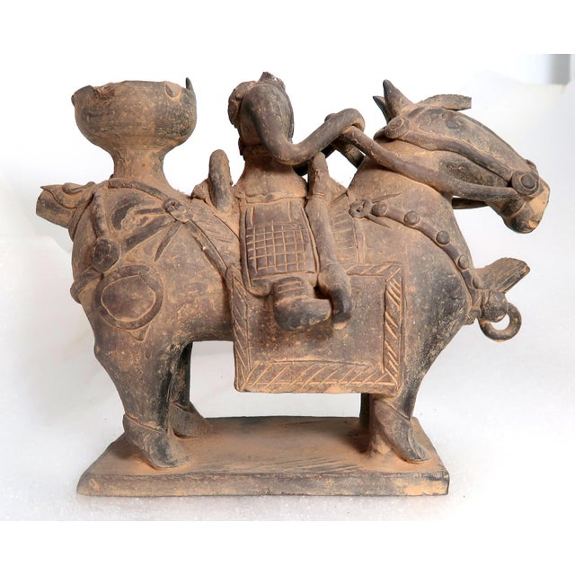 This Pair of antique Korean funerary pottery vessels in the form of riders on horses. The horses are standing four square...