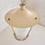 A 1950s Italian lacquered metal lantern pendant with a softly tapered silhouette. The ivory-toned frame descends from a...
