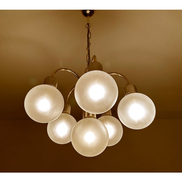 Vintage 1970s pendant lamp featuring a cascade arrangement of four opaline globe glass shades on a chrome and brass...