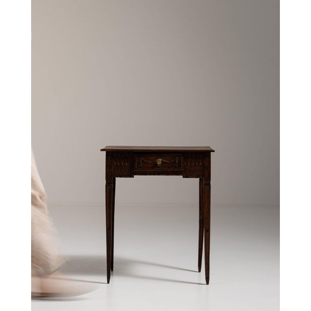 Carved walnut side table with drawer in Rich Walnut Brown. The rich walnut brown surface highlights single drawer, brass...