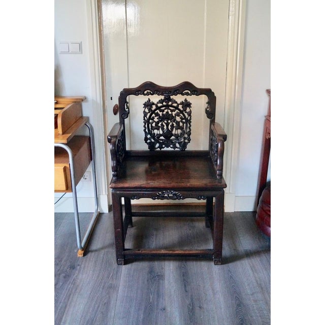 A chinese hardwood chair from the 19th century with exquisite carving on the back and arms. Originally made for a high...