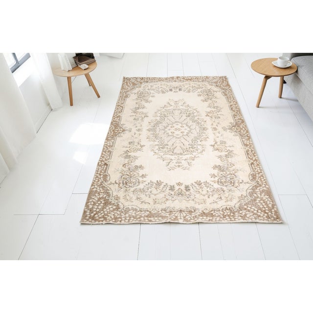 This is a vintage Turkish Oushak rug from the Mid 20th Century. The piece was hand-knotted.