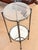 A small round gray metal drink/side table. This has such a nice modern look. It has a glass top and a mirrored bottom shelf..