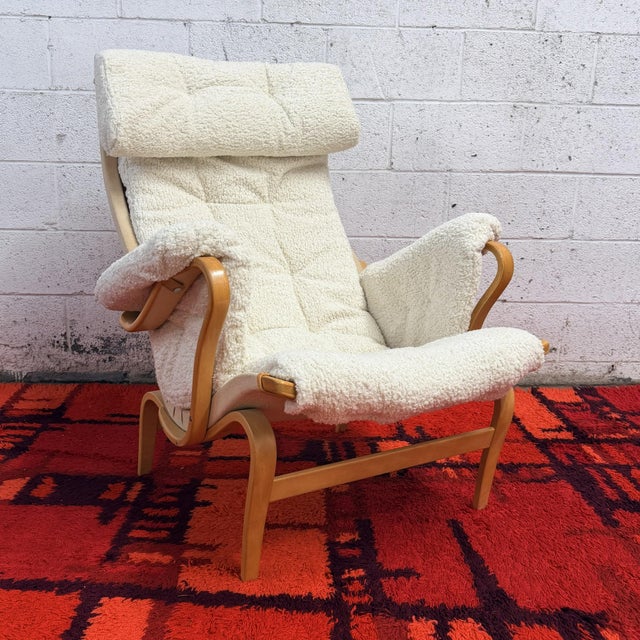 A pair of Pernilla lounge chairs designed by Bruno Mathsson for DUX, with sculpted bentwood frames and brand new ivory...