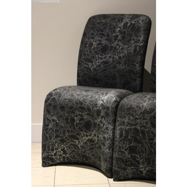 A striking pair of sculptural postmodern chairs upholstered in a dramatic marbleized fabric, blending bold architectural...