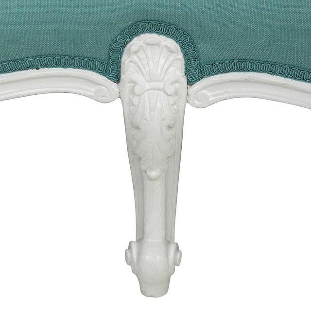 A Louis XV style oversized carved bench with six legs and upholstered in aqua fabric