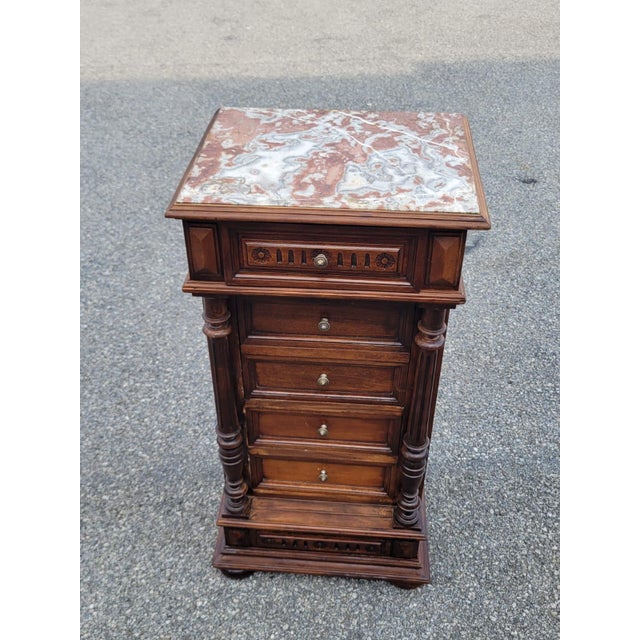Beautiful 19th-century French walnut bedside cabinet featuring a striking marble top, turned columns, paneled drawers, and...