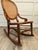 Here is a beautiful antique Victorian rocking chair dating to approximately 1890–1910, featuring a carved wood frame with...