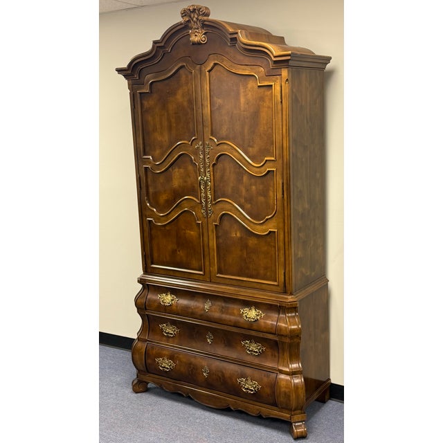 Stunning Bombe Style “Villandry” Collection Armoire by Henredon. This vintage armoire is constructed with burl and walnut...