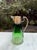 An elegant antique decanter featuring beautifully beveled prism glass in a rich emerald-to-clear gradient with a warm...