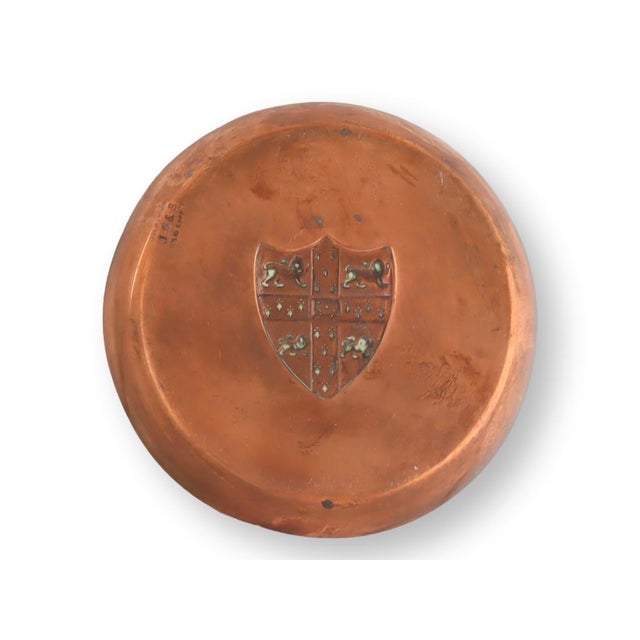 Enhance your collection with this distinguished 4.75" antique English copper dish, showcasing a meticulously embossed coat...