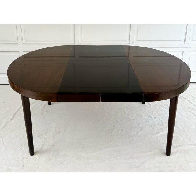 This vintage, mid-century dining table features a classic round form with two removable leaves that allow it to expand for...