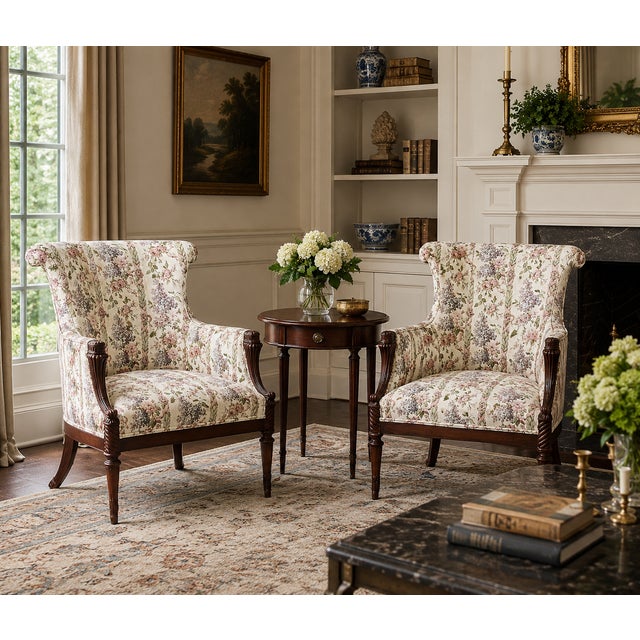 A handsome pair of Georgian Revival mahogany lounge chairs dating to the second quarter of the twentieth century....