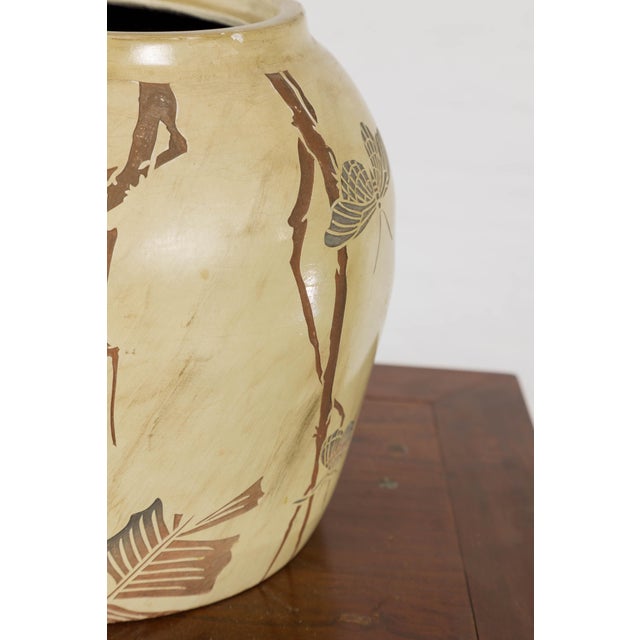 An antique Japanese mustard glaze ceramic planter with incised décoration depicting butterflies and foliage. Crafted with...