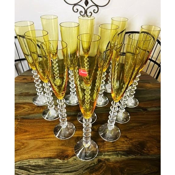 A spectacular collection of thirteen Baccarat Véga Flutissimo champagne flutes in Amber crystal. Designed by Savinel &...