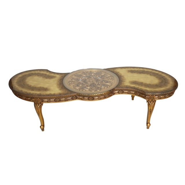 A Hollywood Regency gilt eglomise giltwood coffee table. A central pierced carved medallion is topped with a removable...