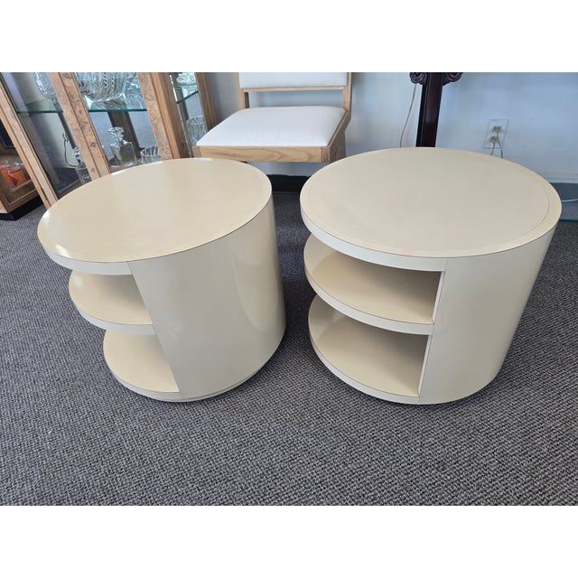 Postmodern rotating drum-style end tables by Saladino. Cream lacquer finish, circular layered shelves, and swivel design.