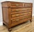An elegant Antique French chest of drawers in oak, featuring a white marble top, five drawers and decorative metal handles...