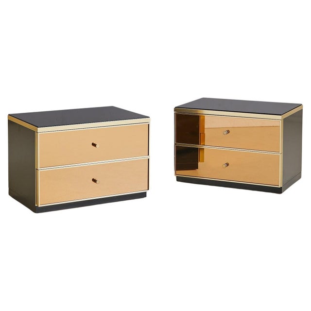 Sold and priced individually. A 1970s Italian two-drawer nightstand attributed to Renato Zevi, clad in bronze mirror with...