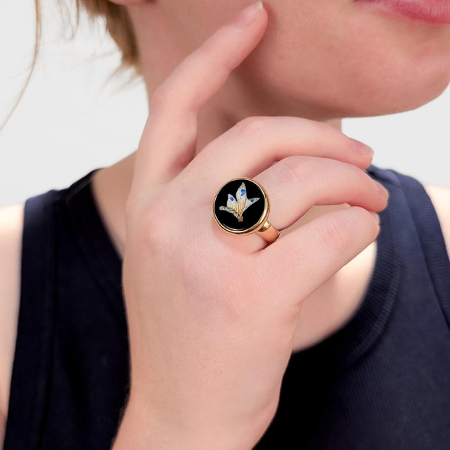A fine English gold and enamel signet style ring. In 9 karat yellow gold. With a raised enamel butterfly on a black glass...