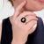 A fine English gold and enamel signet style ring. In 9 karat yellow gold. With a raised enamel butterfly on a black glass...