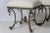 This is a very unusual Italian Silver and Gilt Wrought Iron Scrolled Base Double Stool with new upholstery in French White...