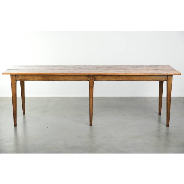 This large and relatively narrow antique French farmhouse dining table is made of pine and dates from the early 19th...