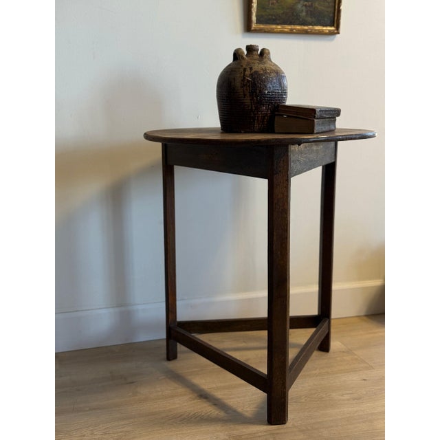 A well-proportioned antique English cricket table, dating to the early 20th century, with its classic round top set over a...