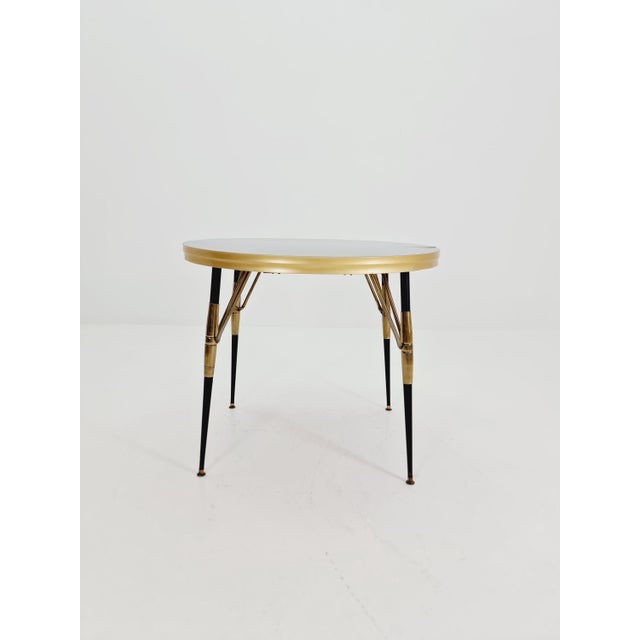 Vintage extendable dining table from the 1950s. The table is in very good condition. Made of wood and brass. Height: 76...